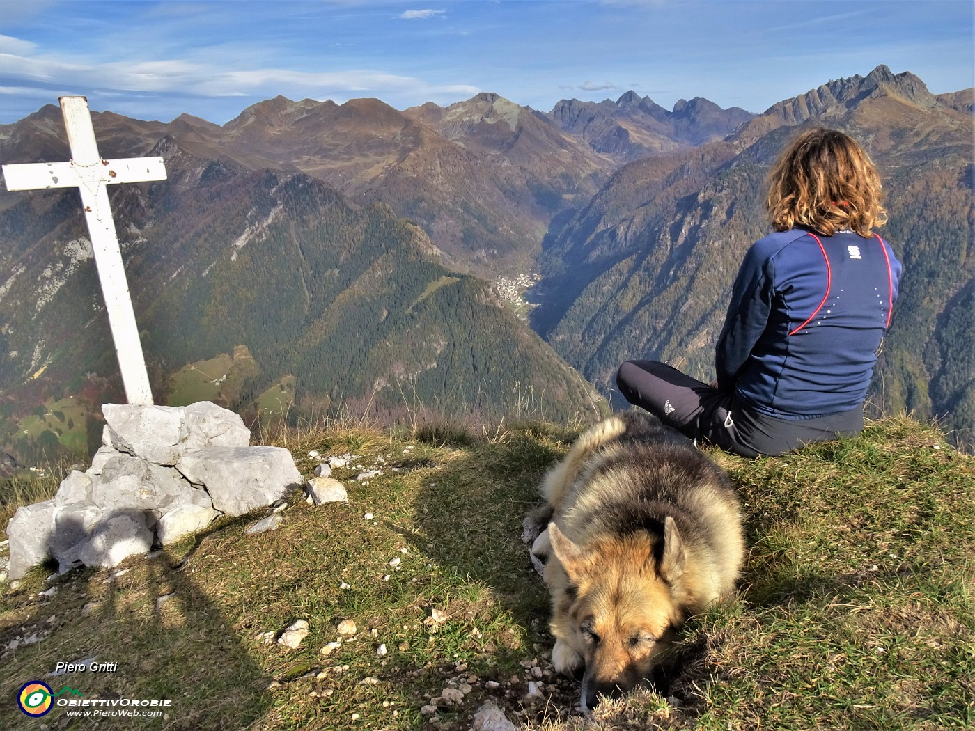 53 Alla croce di vetta del Pizzo Badile (2044 m) vista verso la valle da Carona al Pizzo del Diavolo.JPG